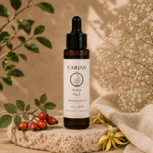 CARIAN RESIN No.1 Night Regenerative Facial Oil bottle with fresh rosehip branch and ylang ylang flower on natural stone